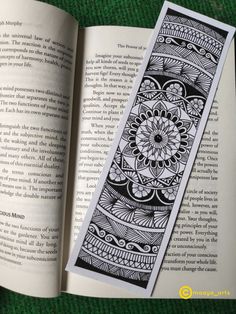 an open book with black and white designs on it