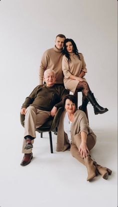 an older man and two younger women sitting on a chair with their arms around each other