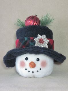 a snowman wearing a hat with a christmas ornament on top