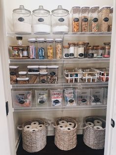 an organized pantry with baskets and jars