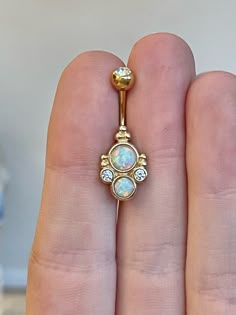 This gold belly button ring features a faux opal in a stunning elegant style. Details & Size: ♥ 316L Surgical Steel ♥ Cubic Zirconia Gems ♥ 10mm bar, 14G ♥ Externally Threaded ♥ Also available in rose gold with purple opal and silver with white opal! ♥ Every purchase comes with an Elara gift box For sanitary purposes, piercing items are non-returnable, so please double check sizing and message me if you have any questions! Gold Belly Button Ring Hoop, Elegant Gold Belly Rings, Cheap Elegant Gold Belly Rings, Real Gold Belly Button Ring, Gold Belly Button Piercing Dangle, Belly Button Piercing Cute, Gold Belly Button Rings, Opal Belly Ring, Bellybutton Piercings