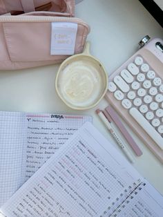 the contents of a pink bag, notebooks, and calculator are laid out on a table