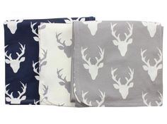 three napkins with deer heads on them, one in blue and the other in grey