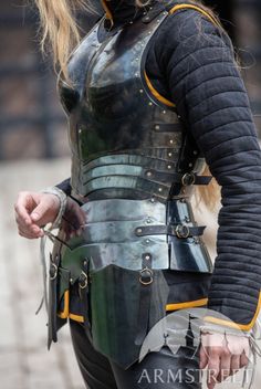 a woman dressed in black and gold armor