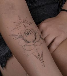 a woman's arm with a flower tattoo on the left side of her arm