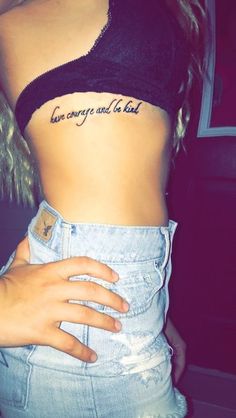 a woman's stomach with the words love conquer and be kind written on it