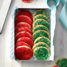 a box filled with red, green and white sugar cookies on top of a table