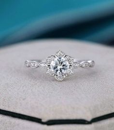 an engagement ring is shown on top of a cushion