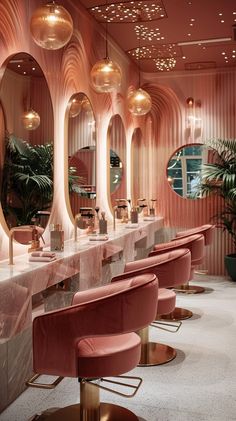 the interior of a pink and gold bar with stools, mirrors and lights on the walls