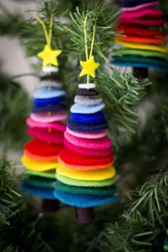 colorful ornaments hanging from a christmas tree in the shape of rainbows with stars on them