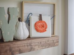 two pumpkins are sitting on top of a mantel with some string wrapped around them