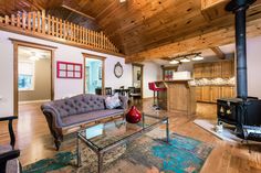 a living room filled with furniture and a fire place next to a wooden floored wall