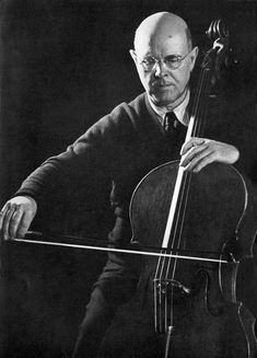 an old photo of a man playing the cello