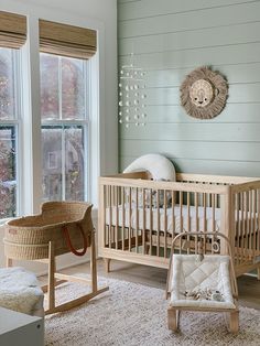 a baby's room with a crib, rocking chair, and window in it