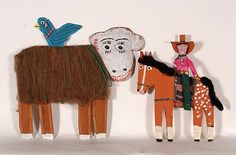 three wooden toy horses and one horse with a bird sitting on it's back