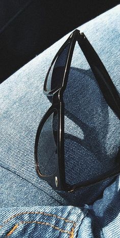 a pair of black sunglasses sitting on the back of someone's jeans