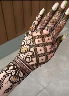 a woman's hand with henna tattoos on it