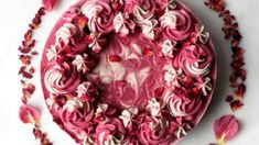 a cake with pink frosting and flowers around it