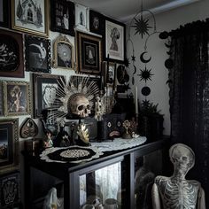 a room filled with lots of framed pictures and skeleton figurines on top of a table