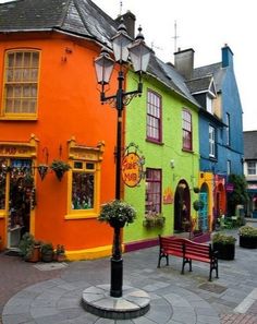 the colorful buildings are painted in different colors and sizes, along with benches on either side