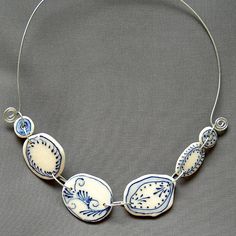 a blue and white necklace on a gray background