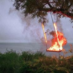 a fire swing is on fire by the water