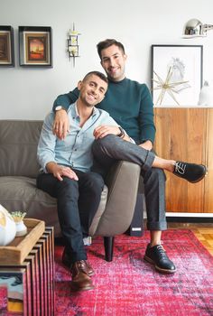 two men sitting on a couch in a living room