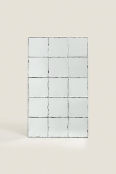 a white square mirror sitting on top of a table