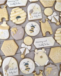 cookies decorated with baby items are displayed on a table in front of a sign that says, mommy and bee