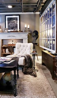 a living room filled with furniture and a fire place in front of a windowed wall