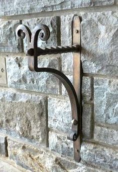 a metal hook on the side of a brick wall