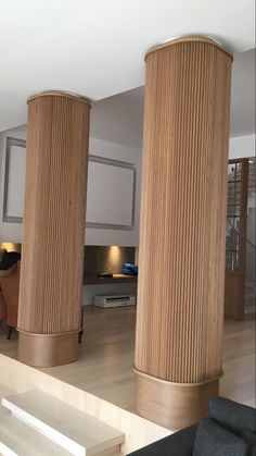 three tall wooden pillars in the middle of a living room