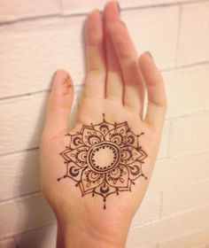 a woman's hand with a henna tattoo on it