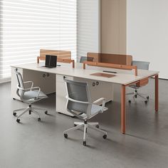 an office desk with two chairs and a laptop on it