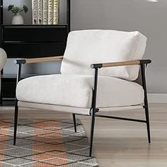 a white chair sitting on top of a hard wood floor next to a book shelf