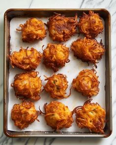 there are many fried food items in the pan on the counter top, ready to be eaten