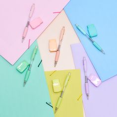 several different colored papers with pens on them