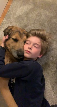 a boy laying on the floor with his dog