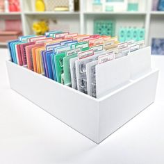 a white box filled with lots of different colored folders on top of a table