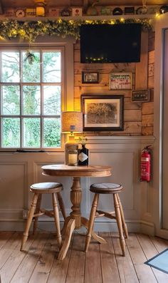 two wooden stools sitting in front of a table