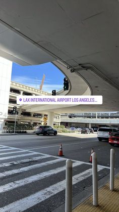 an airport with cars parked in front of it and a sign that says lax international airport los angeles