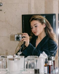 a woman taking a selfie in front of a mirror