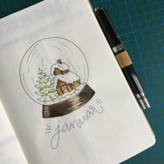 an open notebook with a drawing of a snow globe and a christmas tree in it