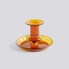 an orange glass candle holder on a white background