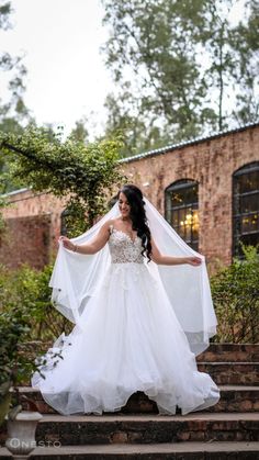 a woman in a wedding dress standing on some steps