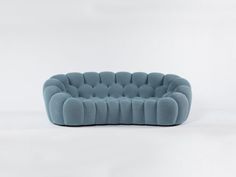 a blue couch sitting on top of a white floor