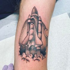 a tattoo on the arm of a man with a rocket ship