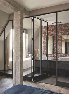 an image of a bathroom with brick walls and glass doors that open up to the bathtub