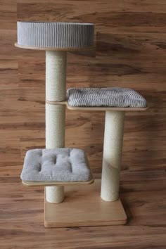 a cat tree with two scratching posts and a cushion on the bottom one pole is made out of wood