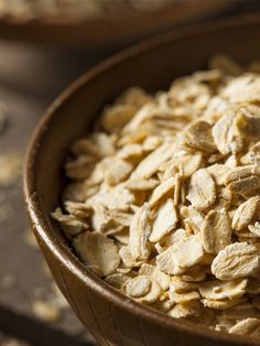 a wooden bowl filled with oatmeal sitting on top of a table